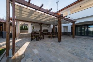 Beautiful terrace lounge with pergola and wooden table with chairs